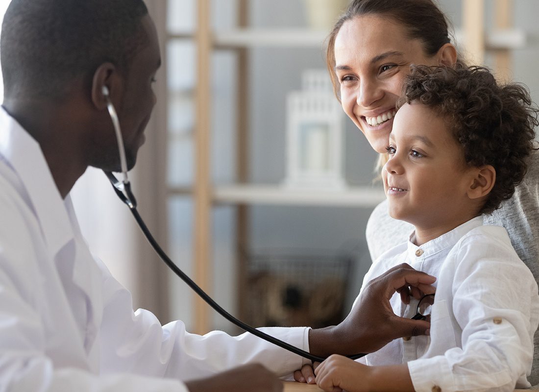 Insurance by Industry - Friendly Doctor Checking the Heartbeat of a Happy Child During a Visit